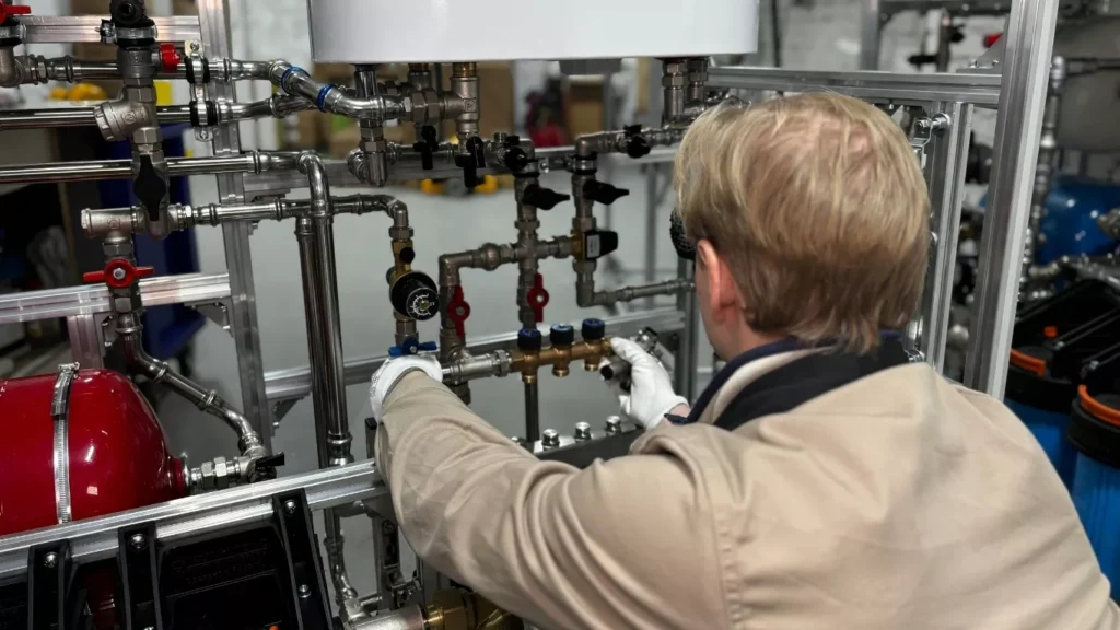 Technician providing plumber services for residentials fixing kitchen sink